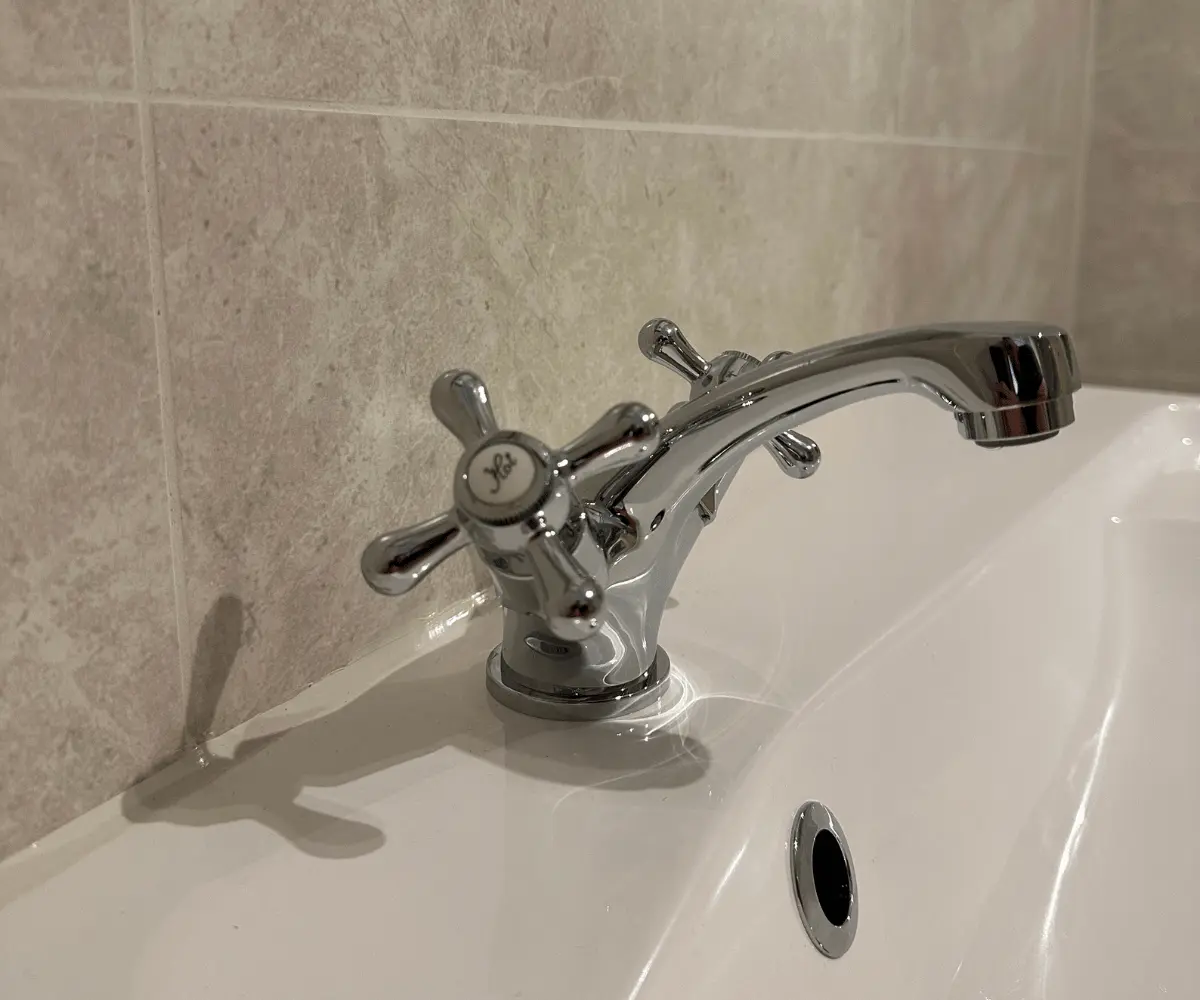 Bathroom renovation showing grey tiling with traditional style basin mixer tap installation by plumbers in taunton plumb inc.