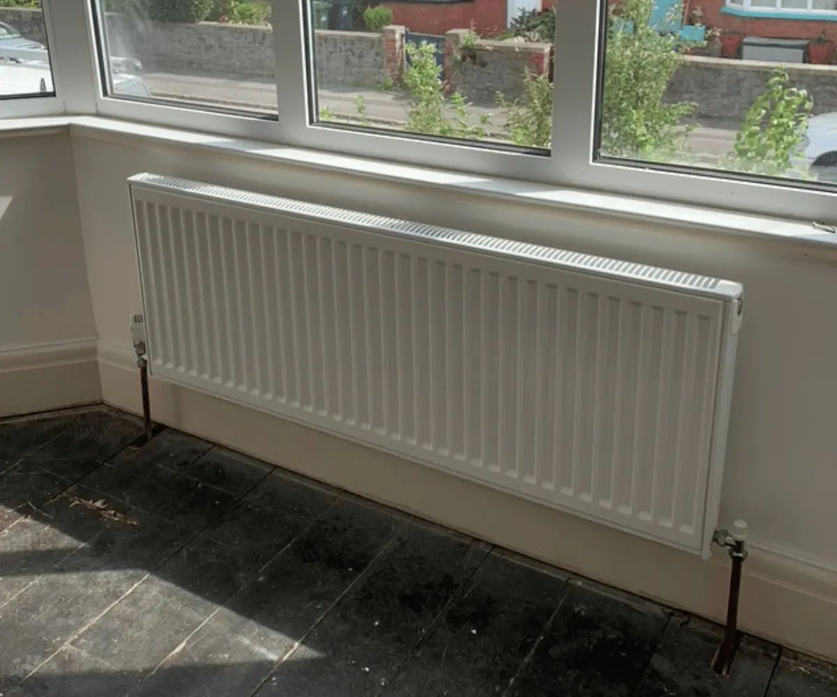 White convector radiator installation in bay window by plumbers in taunton somerset.